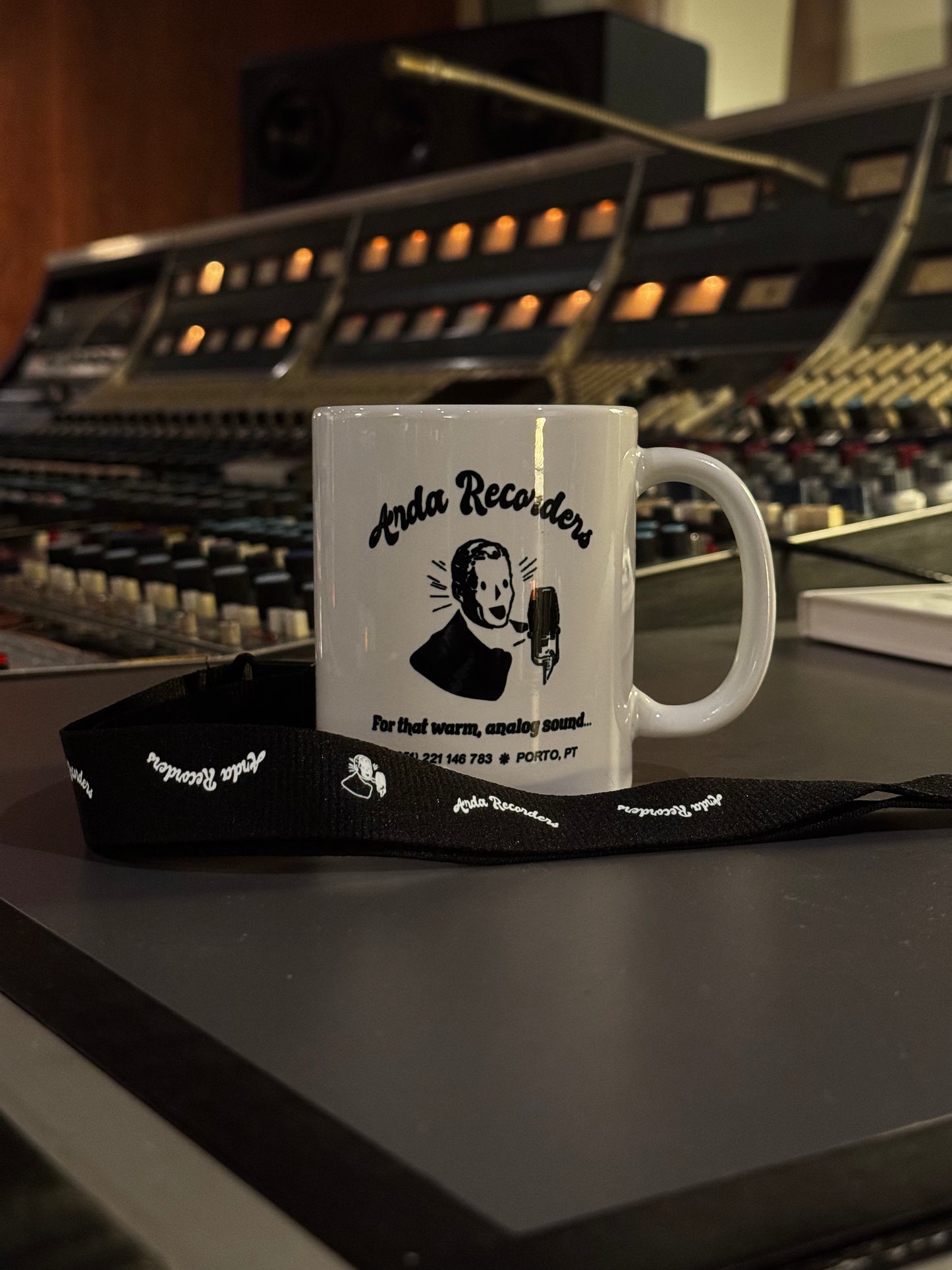 Arda Recorders branded black lanyard displayed with studio mug in analog recording studio
