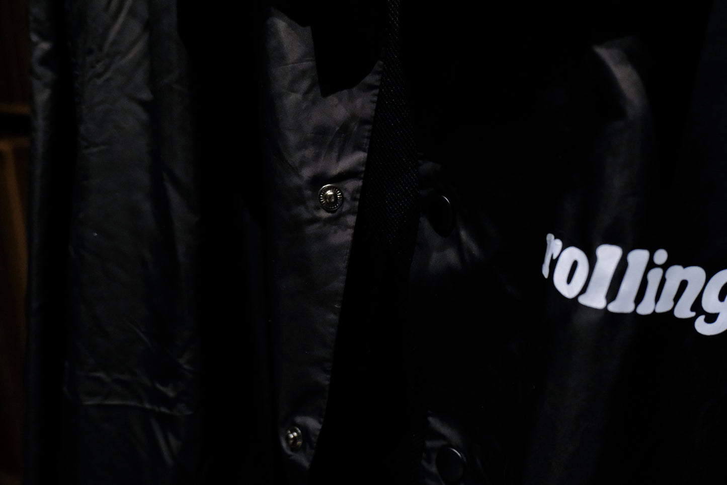 Close-up of a Warm Analog black coach windbreaker jacket for recording studio lifestyle with rolling in the front