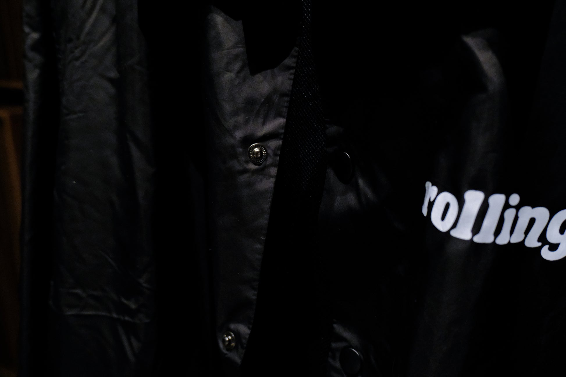 Close-up of a Warm Analog black coach windbreaker jacket for recording studio lifestyle with rolling in the front