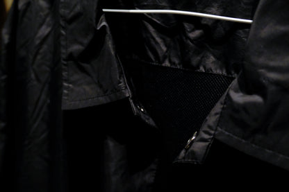 Close-up of a Warm Analog black coach windbreaker jacket for recording studio lifestyle